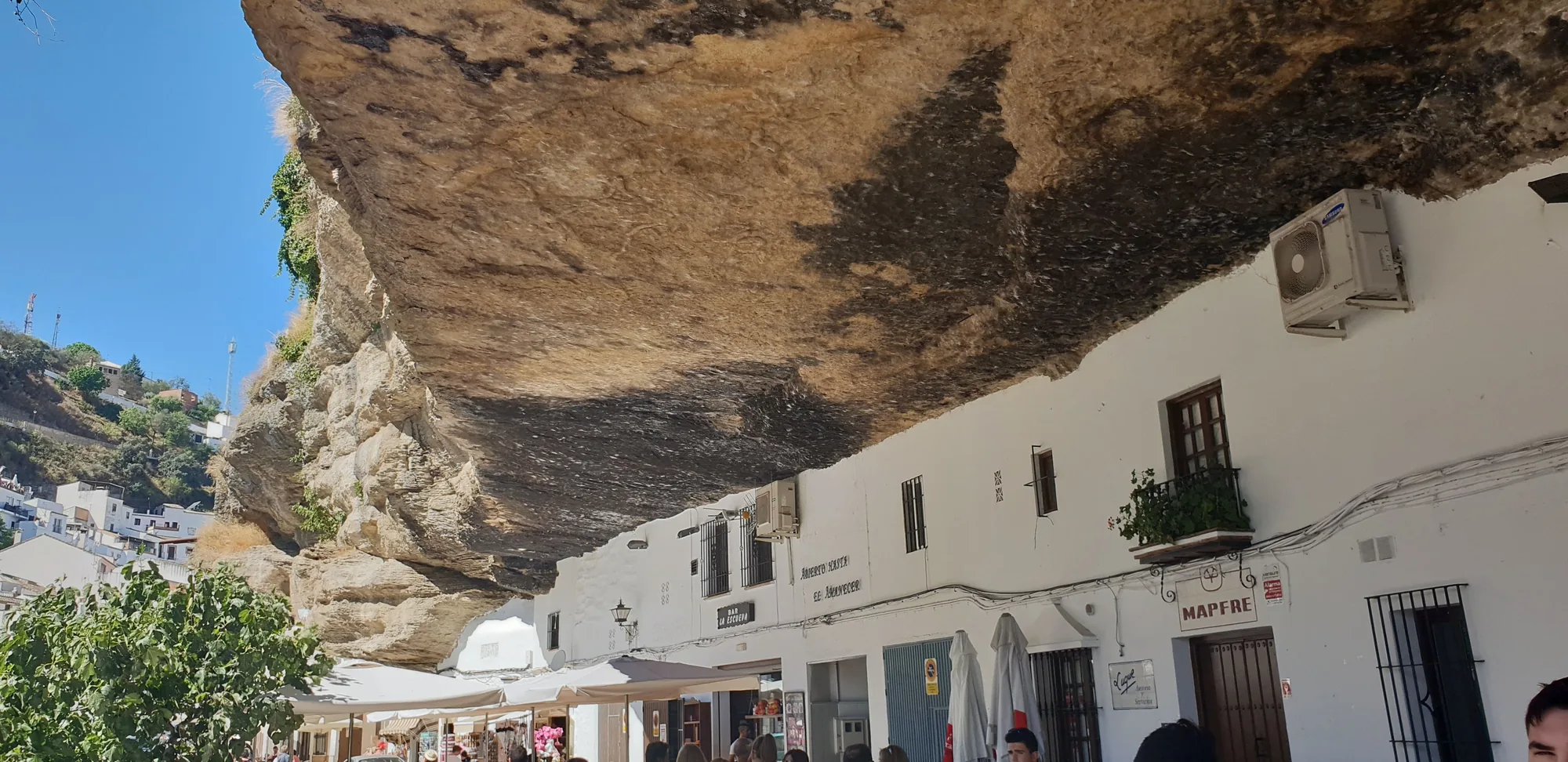 Calle con casas blancas construidas bajo un gran saliente de roca en Setenil de las Bodegas