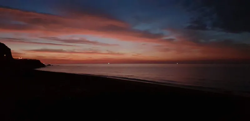 Cielo de rojos y azules oscuros antes del amanecer sobre una playa
