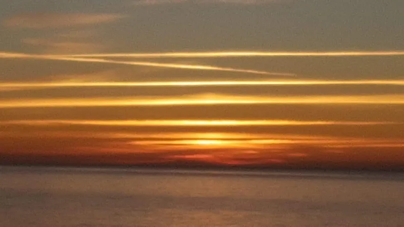 Bandas doradas de luz sobre el horizonte del mar
